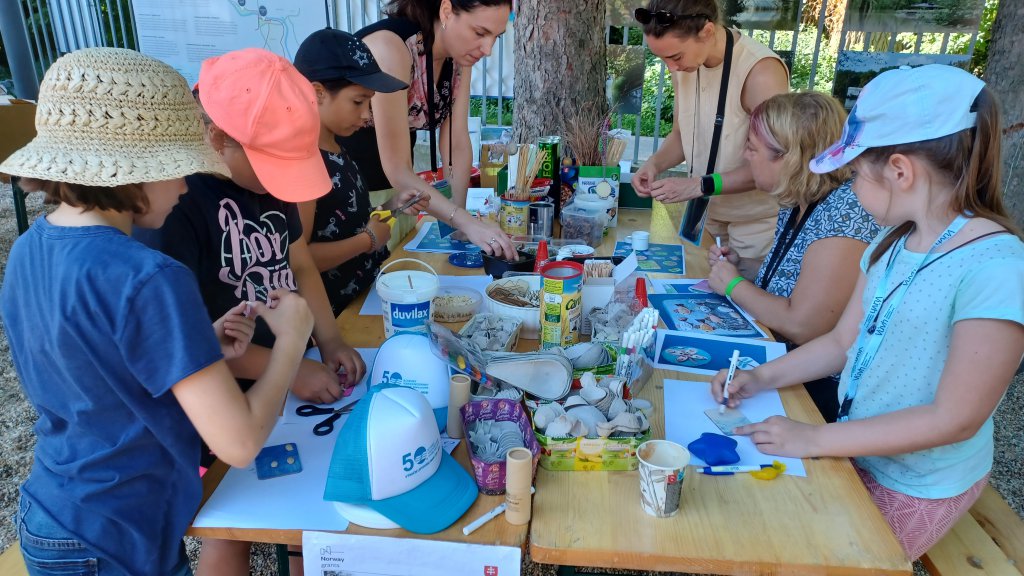A group of kids gather around a table for arts and crafts. 