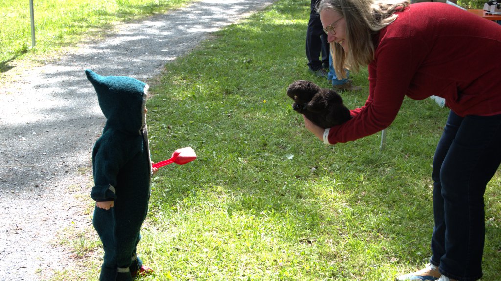 A woman talks to a young boy outside. 