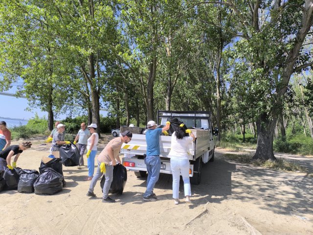 People putting collected litter in back of a pickup truck.