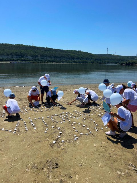 Group of children in front of water.