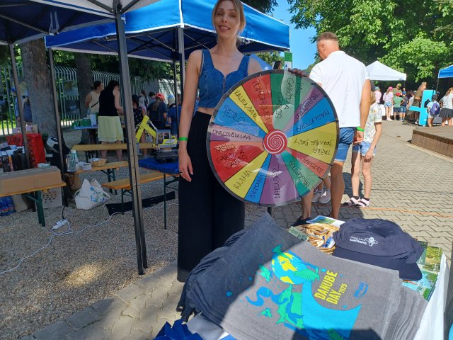 A woman holds a colourful spinning wheel. 
