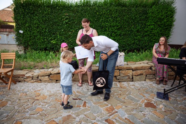 Czech Minister shakes hands with little boy at Danube Day event. 