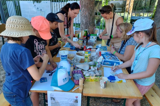 A group of kids gather around a table for arts and crafts. 