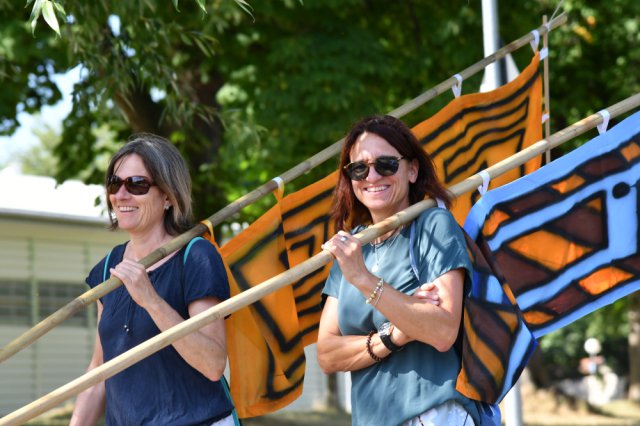 Two women carrying flags 