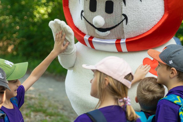 A child playing with a mascot 